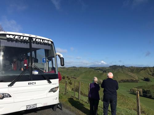 Elderly couple outside a tour bus